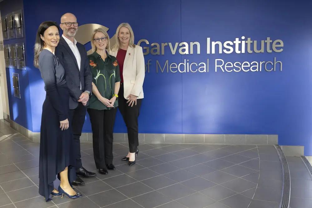 Image of four people standing infront of the Garvan Institute sign