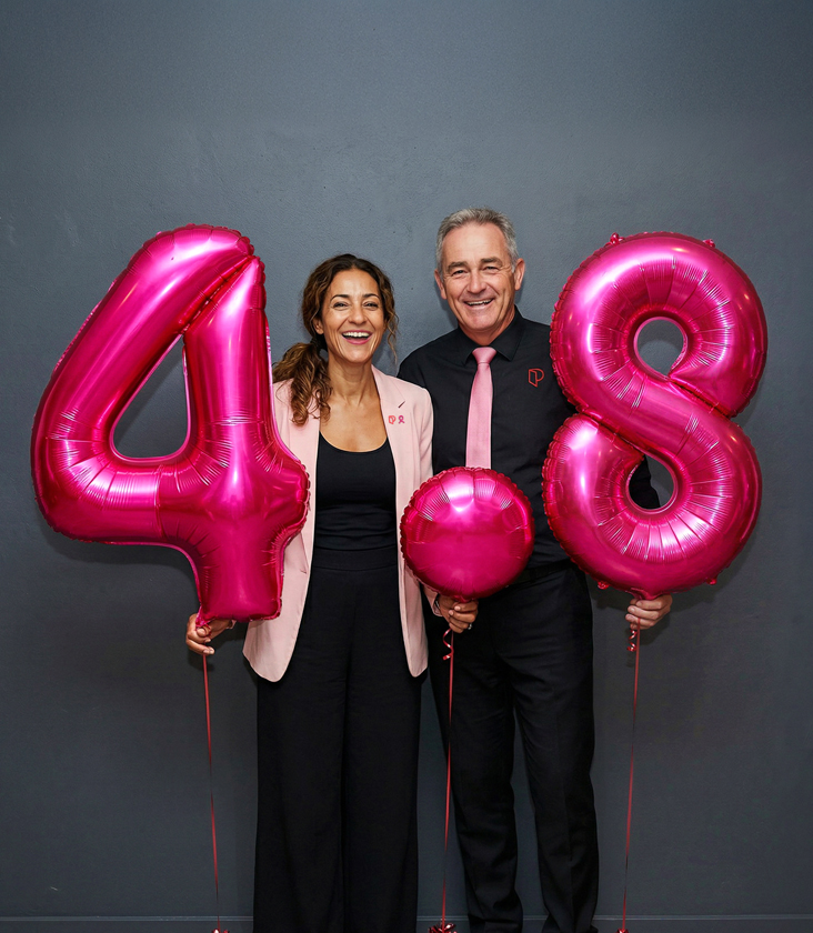 Image of a man and a woman holding pink balloons 