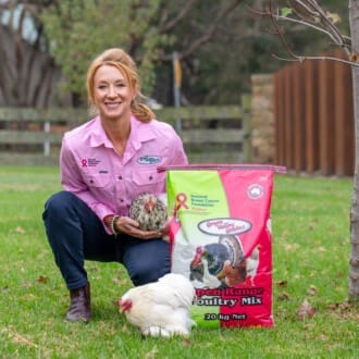 Image of a woman next to a bag of poultry mix and a chicken