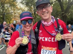 Two marathon runners holding their finisher medals