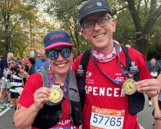 Two marathon runners holding their finisher medals