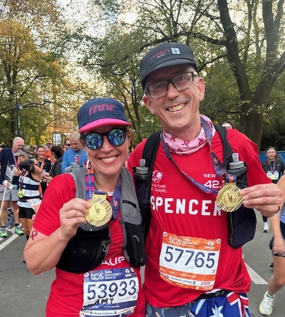 Two marathon runners holding their finisher medals