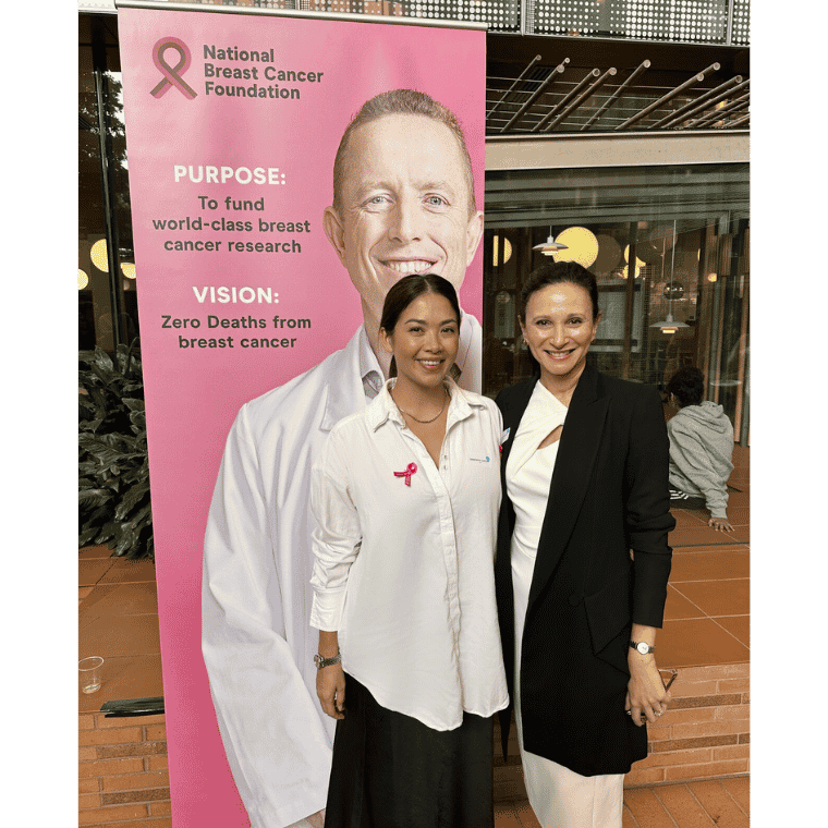 Image of two women standing in front of a NBCF research sign